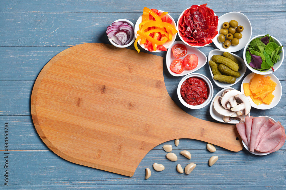 Ingredients for tasty pizza and board on wooden background