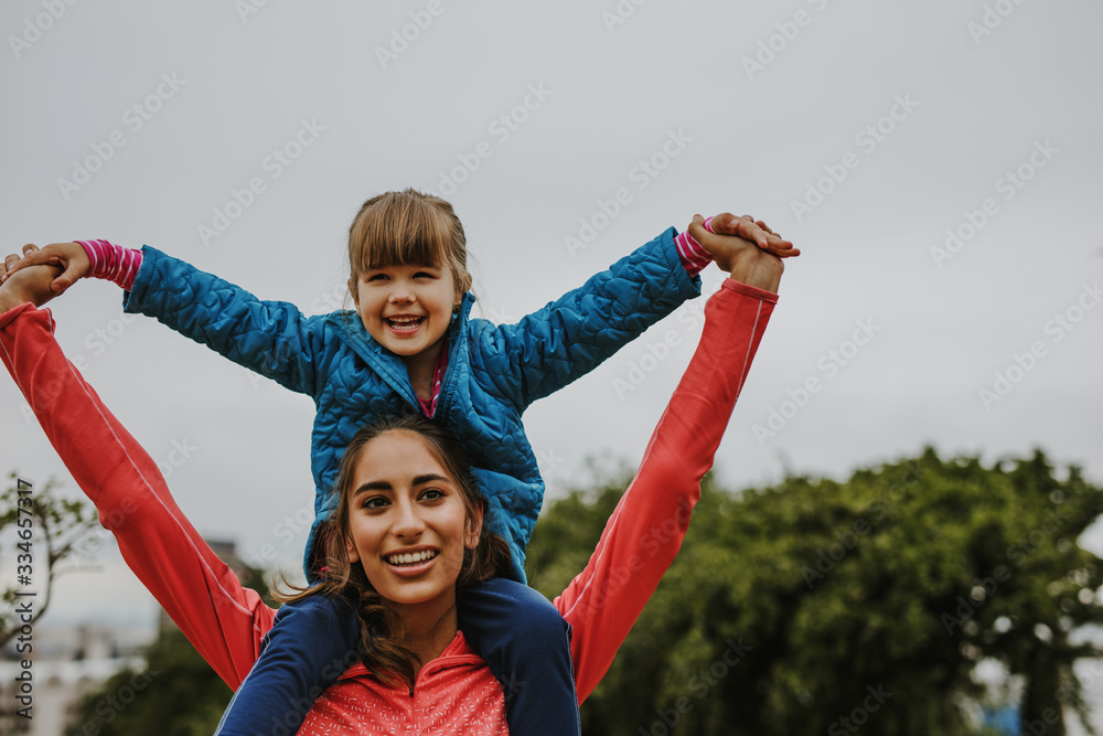 Woman carrying a girl on her shoulder