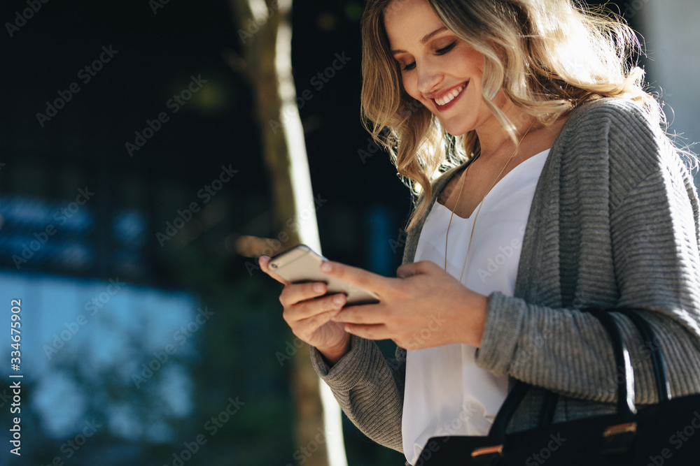 Woman walking in the city using her cell phone