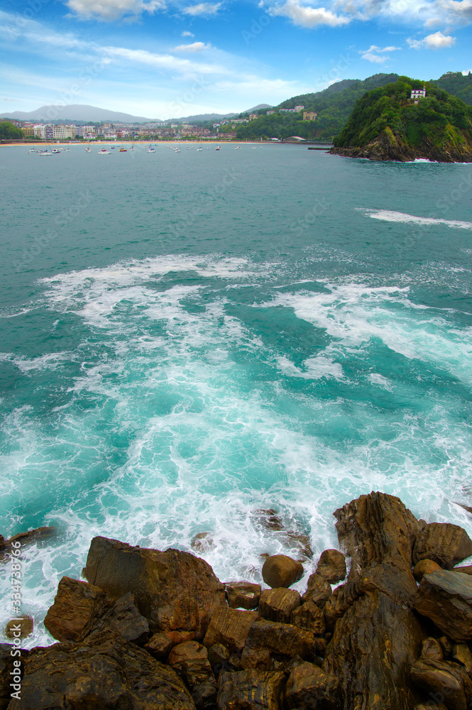 Ocean wave crashing on rock in the bay