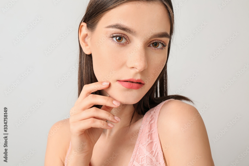 Young woman with beautiful makeup on light background