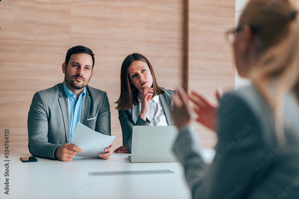 Portrait of attentive hr managers listening to a woman on a job interview.