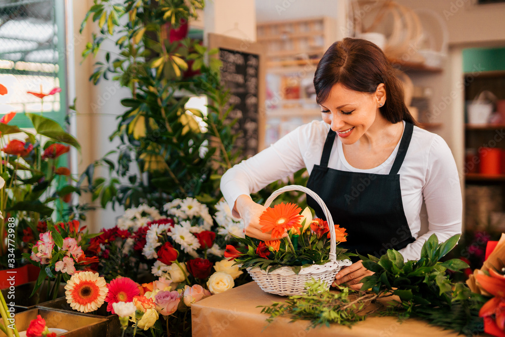 Lovely florist making flower basket for a client, portrait.