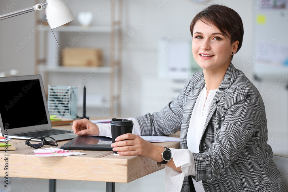 Portrait of young female designer in office