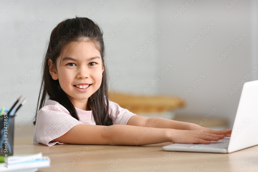 Little Asian girl doing lessons at home