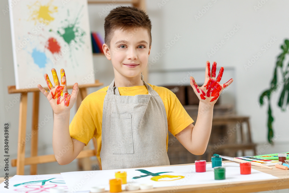 Cute little boy painting at home