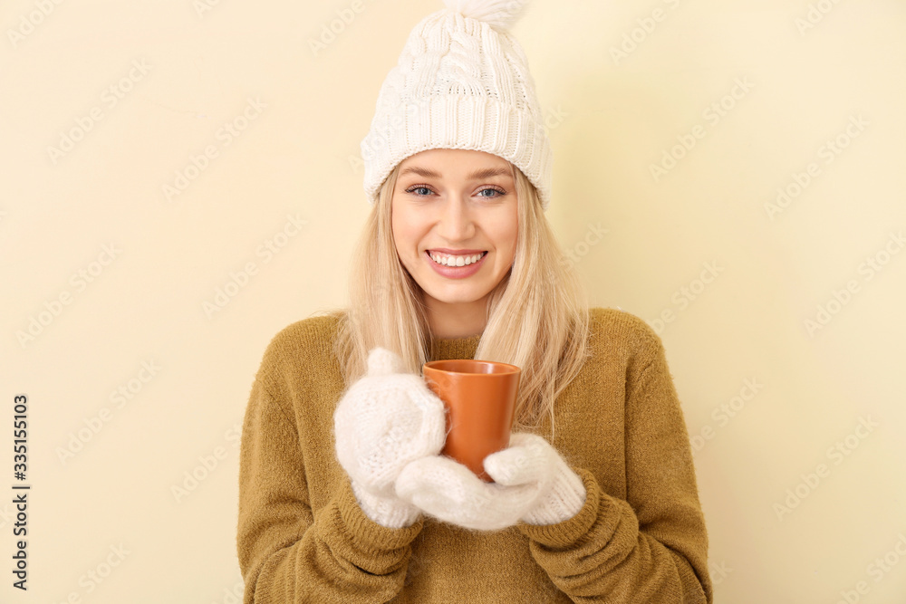 Beautiful young woman with tea on color background