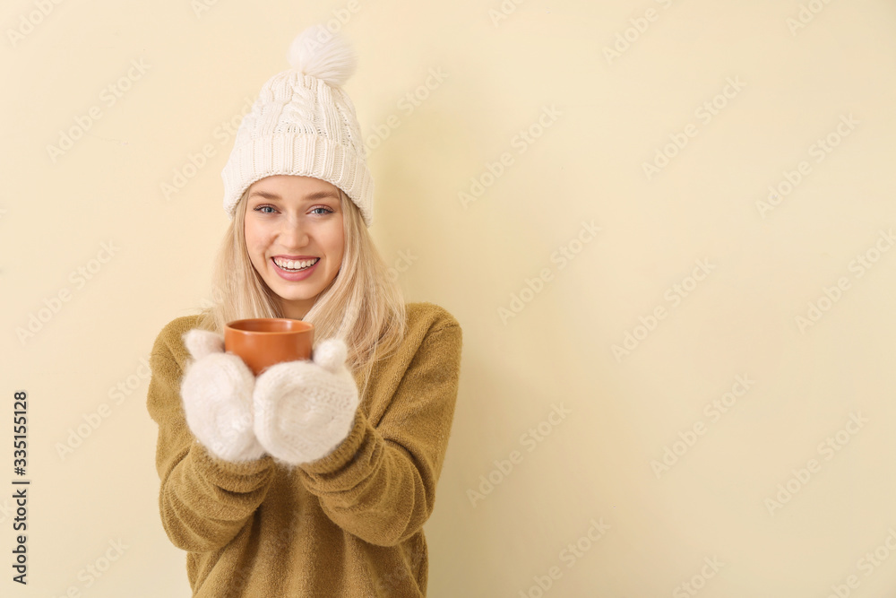 Beautiful young woman with tea on color background