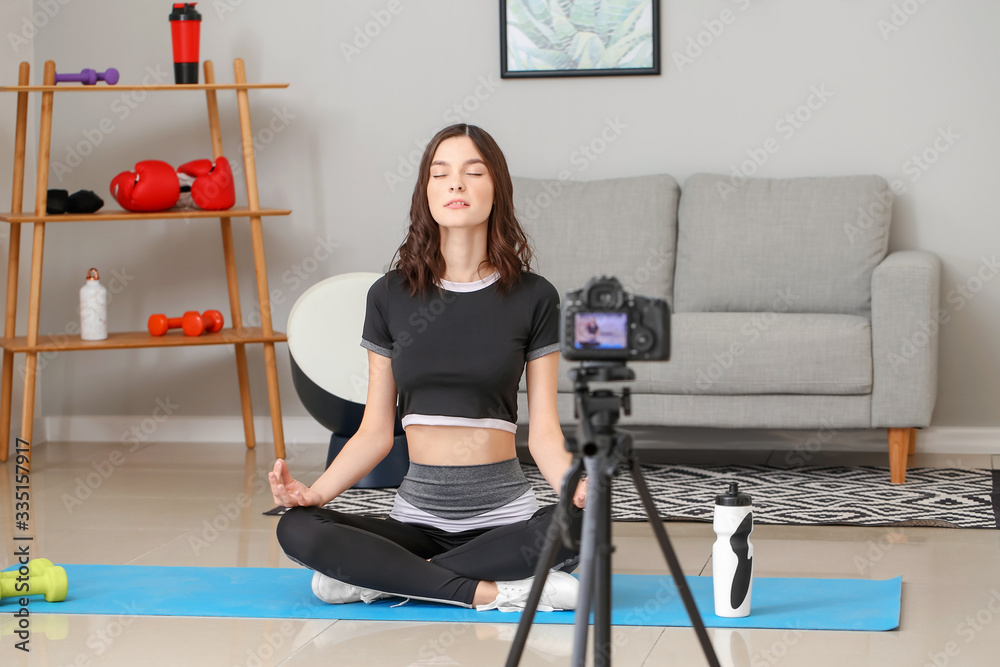 Young female blogger recording sports video at home