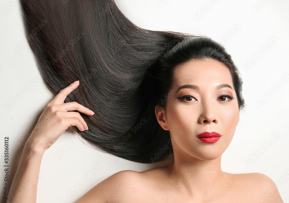 Young Asian woman with beautiful hair on white background