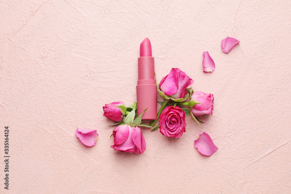 Lipsticks and flowers on color background