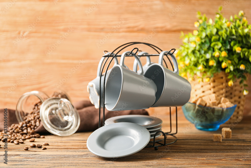 Holder with cups and saucers on kitchen table