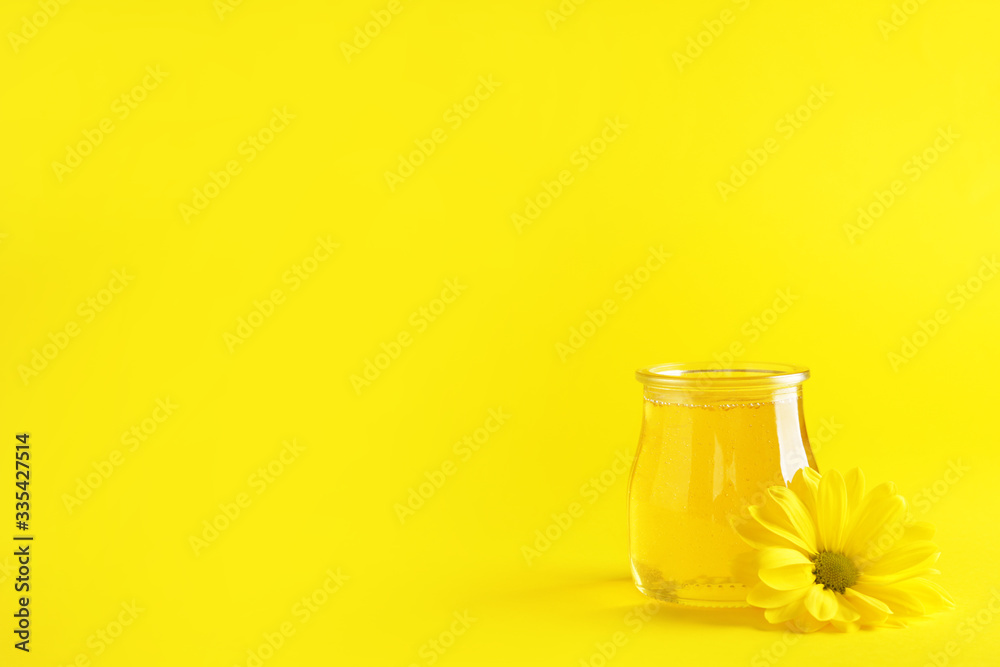 Jar of sweet honey on color background