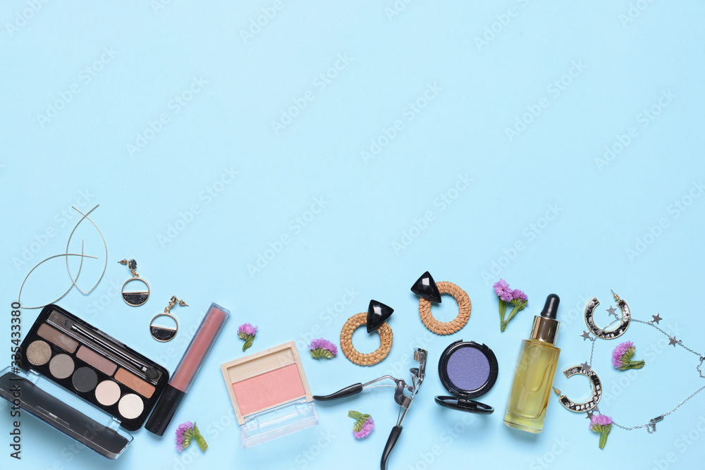 Makeup cosmetics with accessories on color background