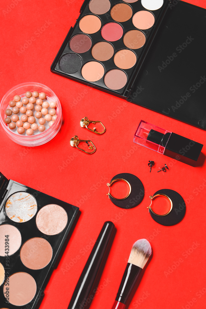 Makeup cosmetics with accessories on color background