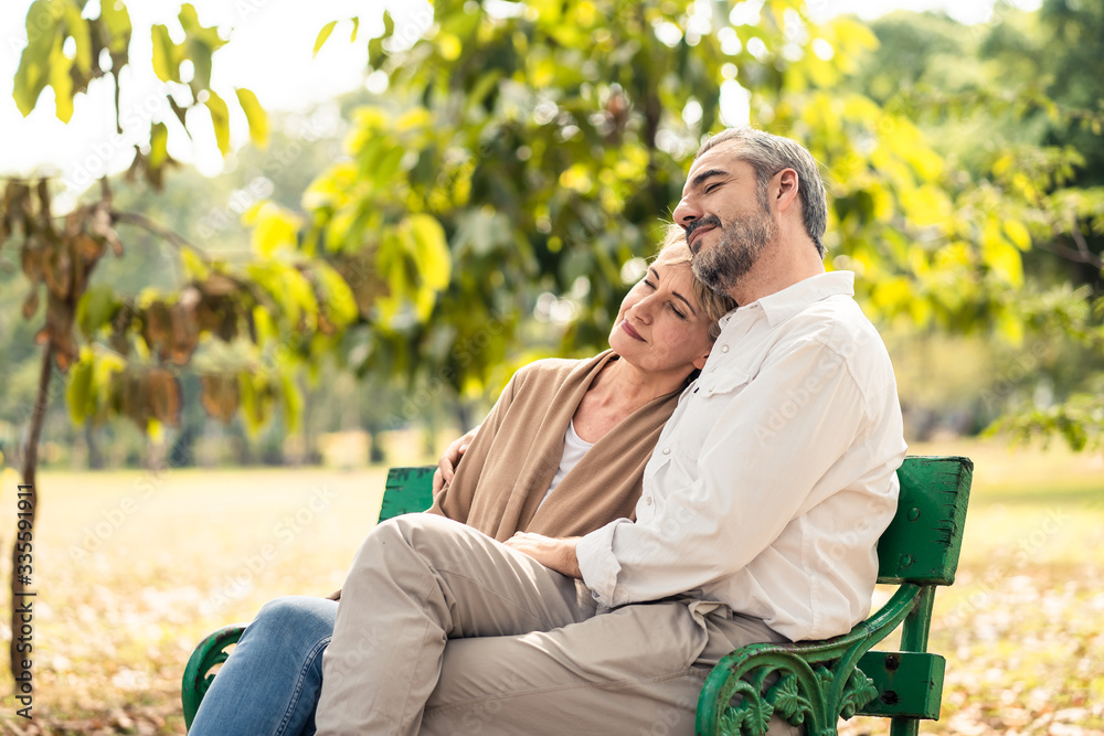 Caucasian senior elder couple sit on bench in park. Mature happy and enjoy with slow life. Old man h