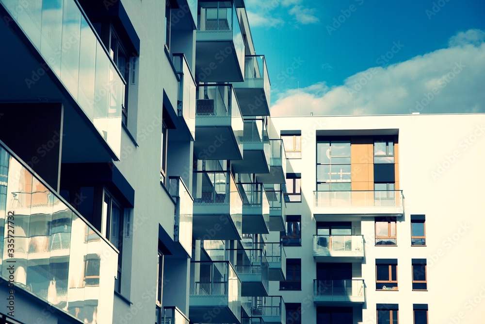 Exterior of new apartment buildings on a blue cloudy sky background. No people. Real estate business