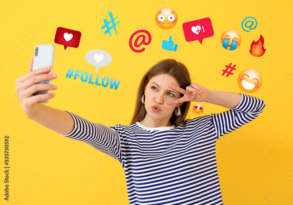 Beautiful female blogger taking selfie on color background