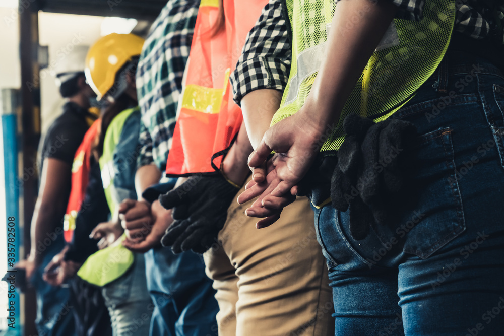 Factory workers standing in a row showing teamwork and unity. Labor and job concept.