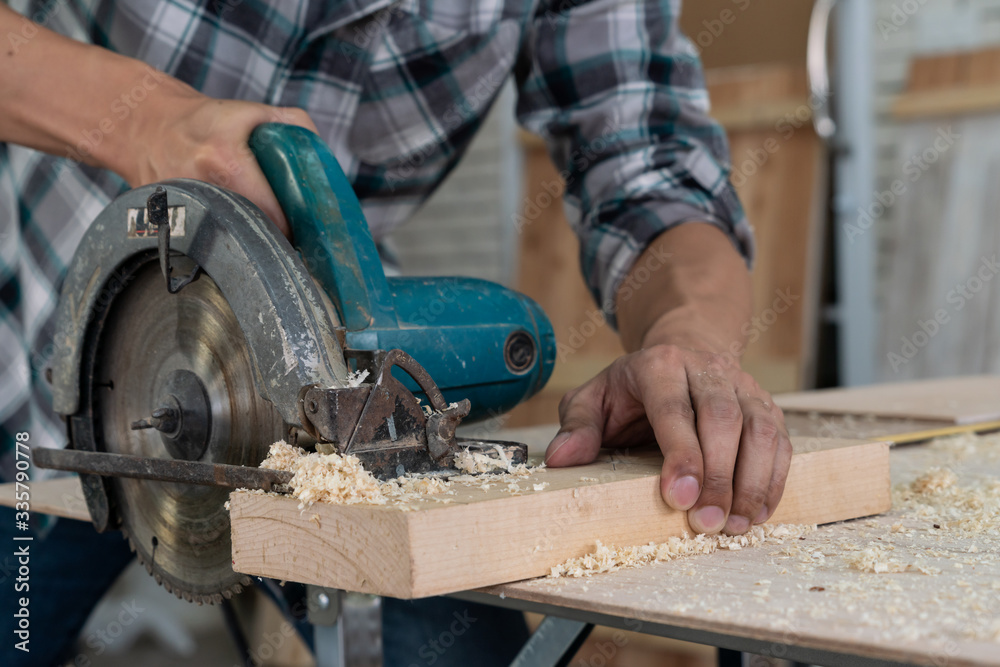 Carpenter working on wood craft at workshop to produce construction material or wooden furniture. Th