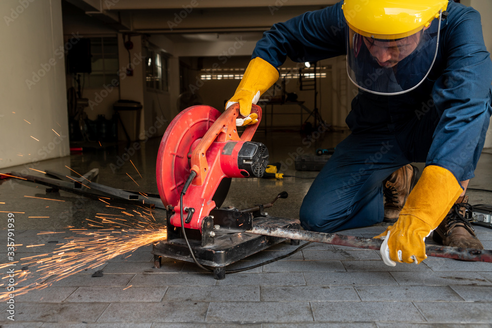 Professional mechanic is cutting steel metal with rotating diamond blade cutter. Steel industry and 