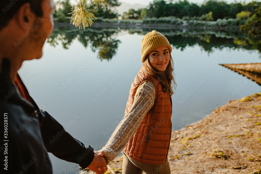 Happy couple on a camping trip walking near a lake