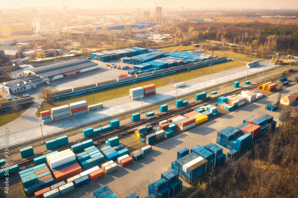 Aerial view of container loading and unloading at sunset. Top view of containers at logistics termin