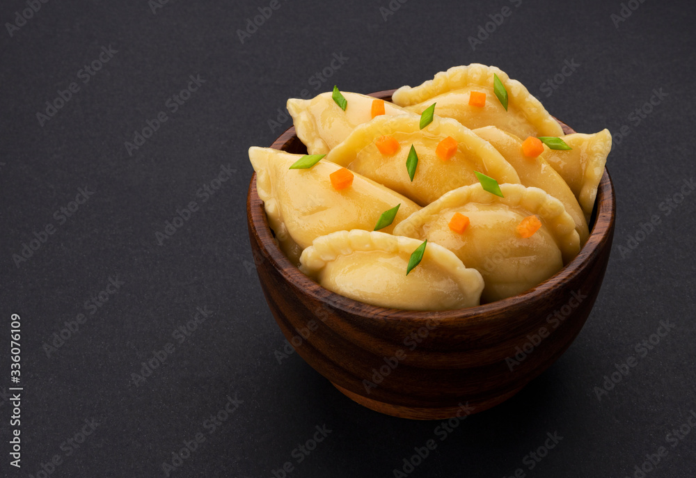 Dumplings, russian vareniki, pelmeni on black background