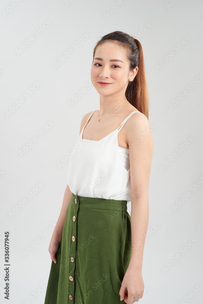 Happy young Asian woman standing over white background.