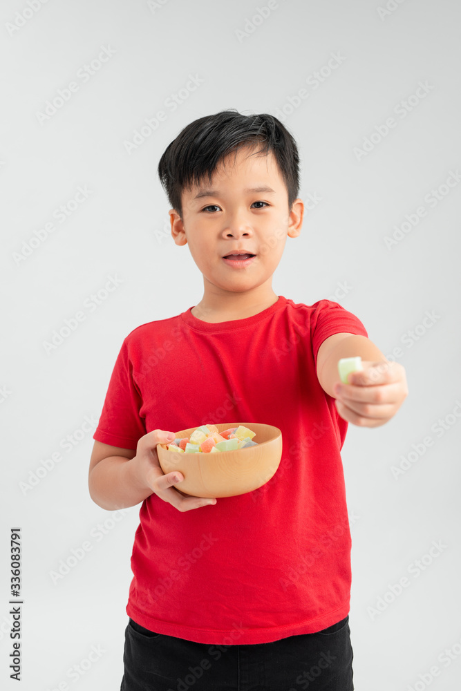 Smiling child with colored sweets and jelly candies on a white background