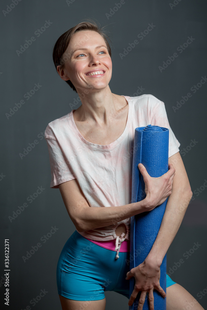 Sporty yoga girl with yoga mat isolated over grey background