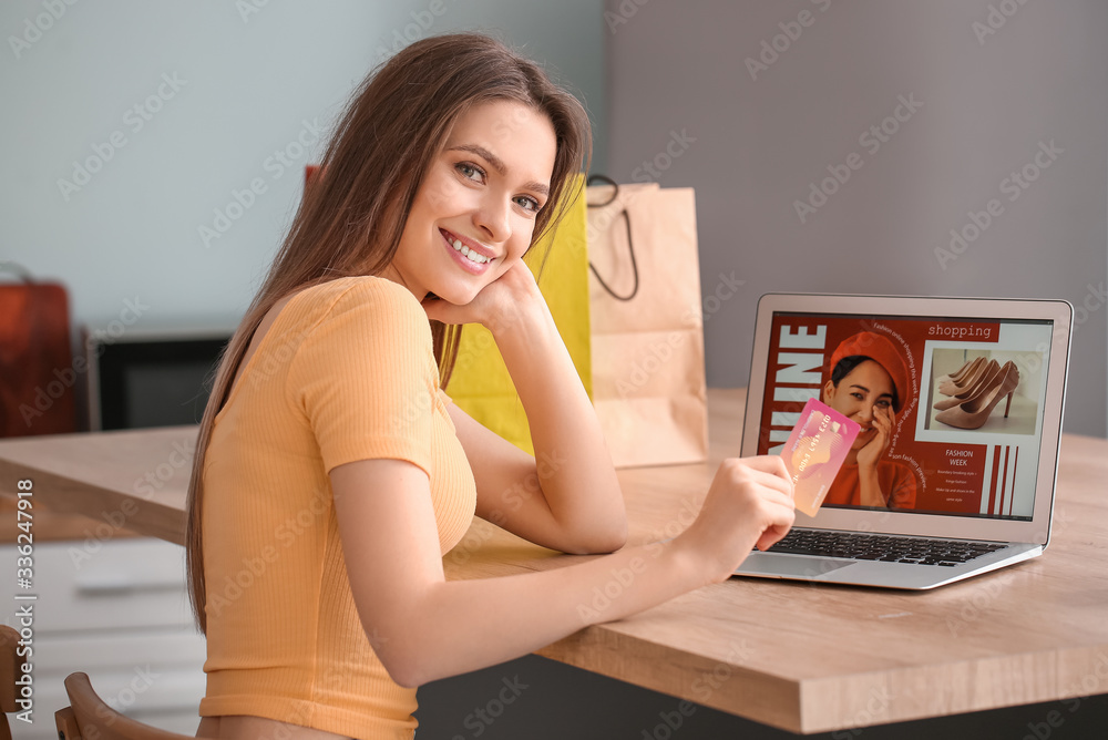 Young woman with laptop and credit card at home. Online shopping concept