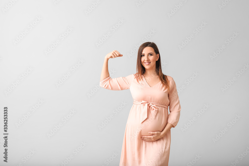 Beautiful pregnant woman on grey background