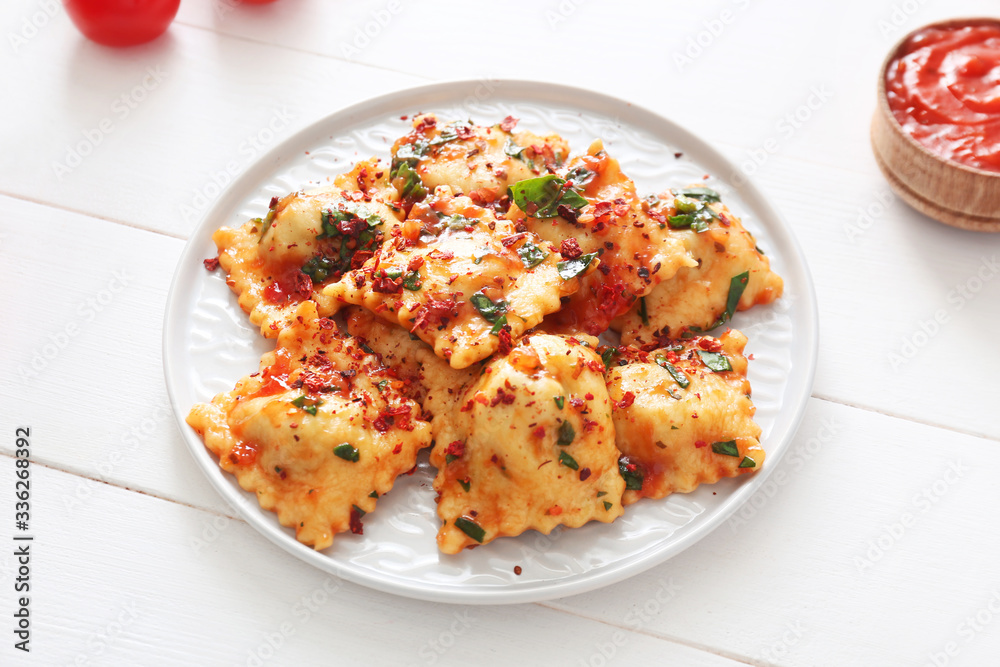 Plate with tasty ravioli on table