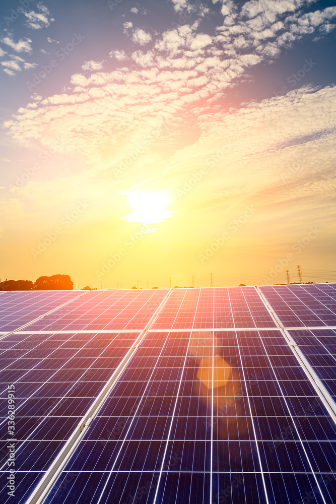 Photovoltaic solar panels and high voltage power lines at sunset sky background,green clean alternat