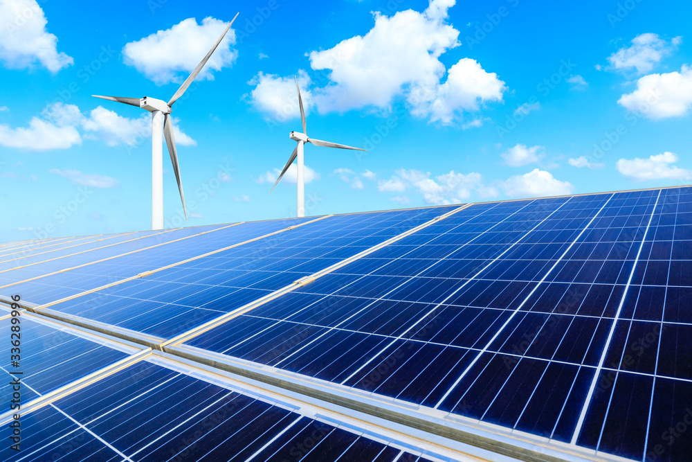 Solar panels with wind turbines on a sunny day,green clean energy concept.