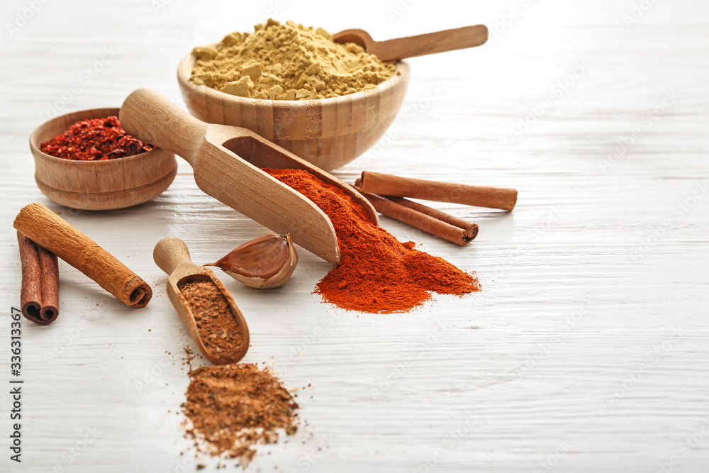 Different spices on white wooden background