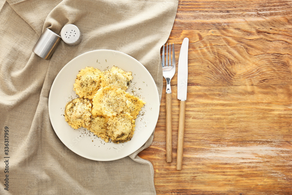 Plate with tasty ravioli on table