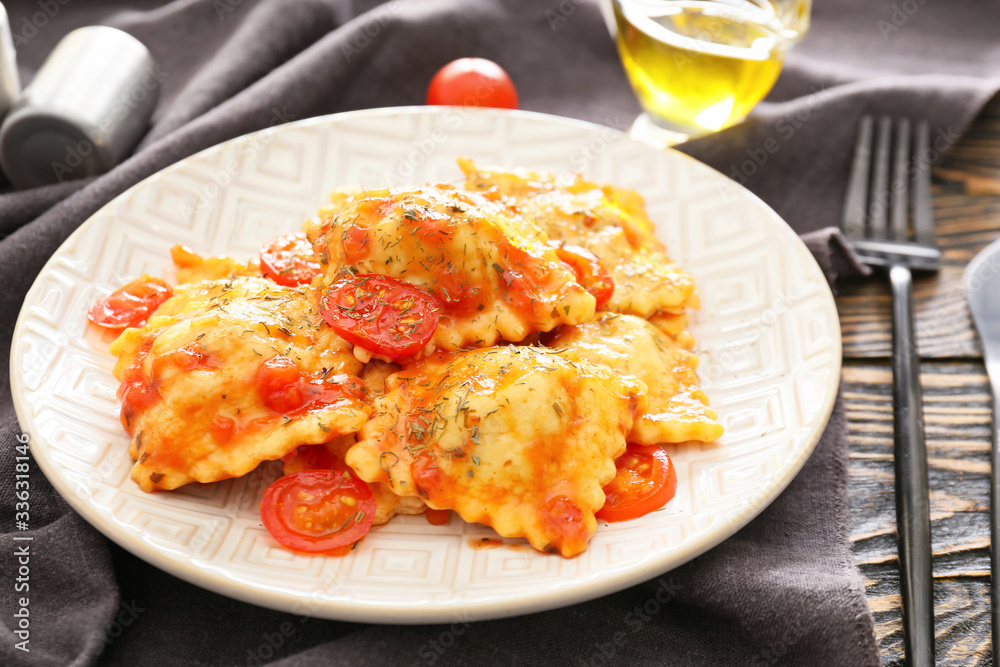 Plate with tasty ravioli on table