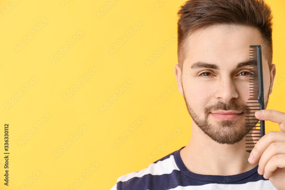 Handsome young man with comb on color background