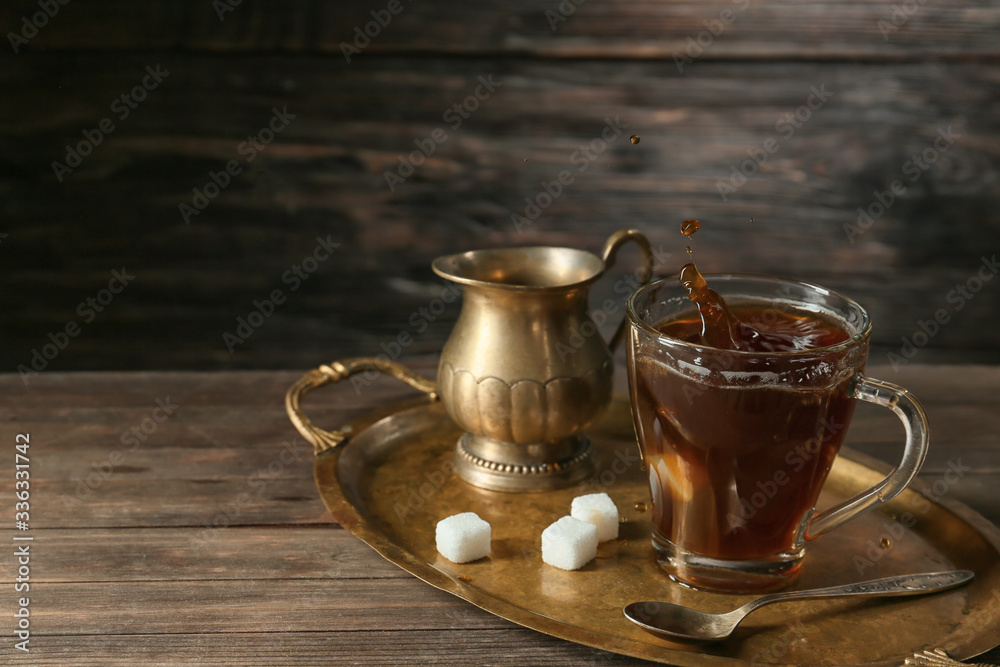 Splashing of coffee in glass cup on table