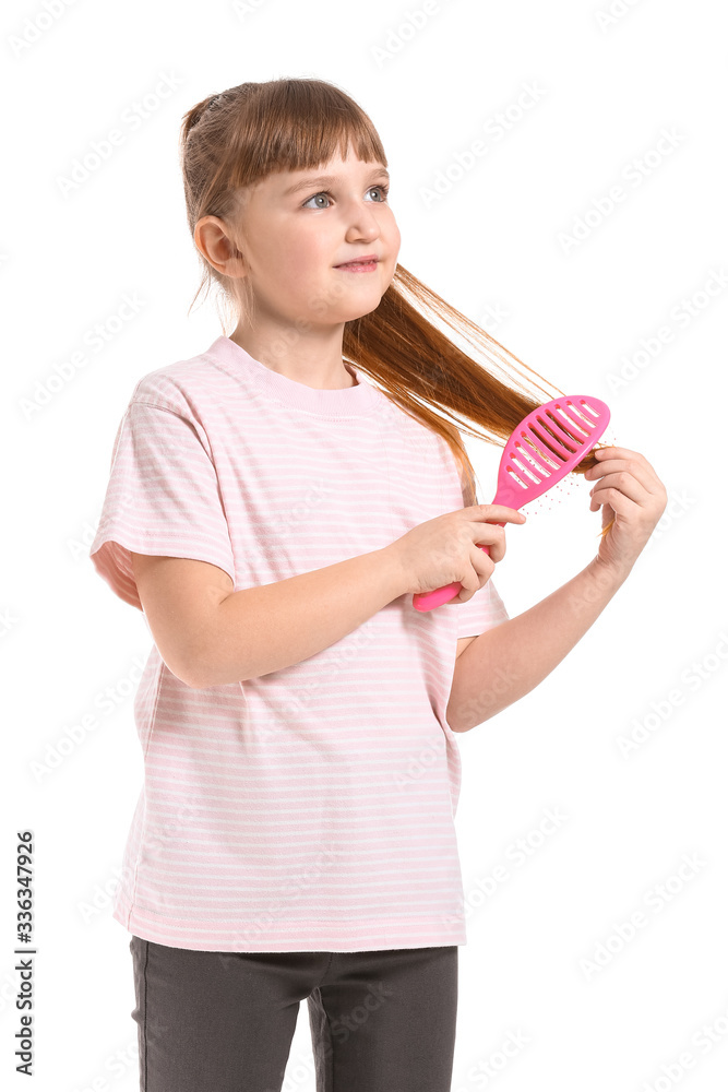 Little girl brushing hair on white background