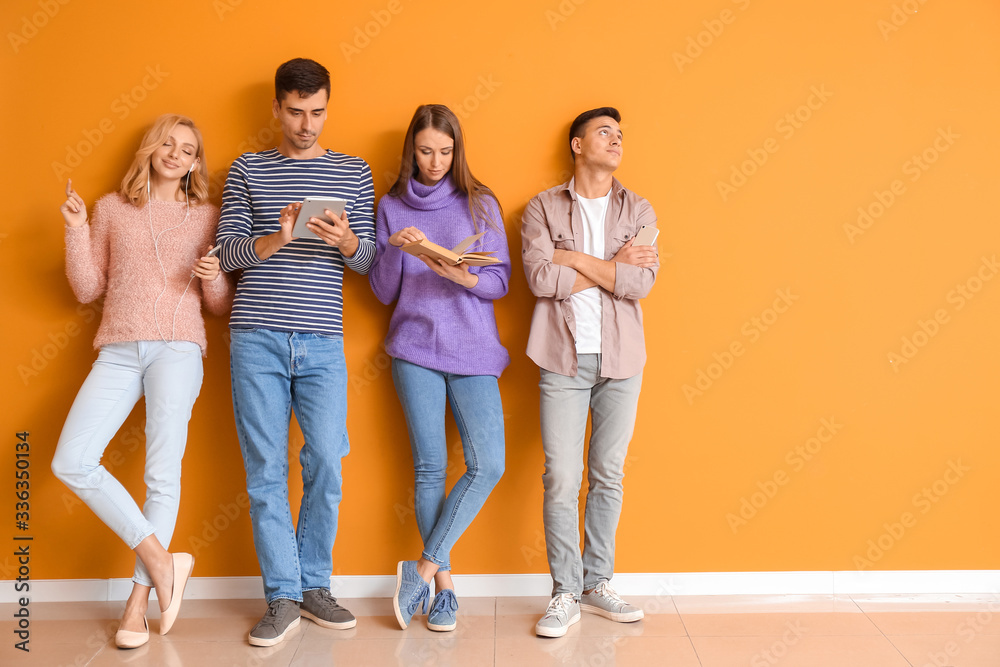 Young people waiting in line near color wall