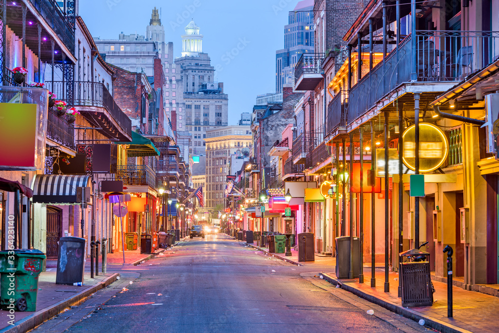 Bourbon St, New Orleans, Louisiana, USA cityscape of bars and restaurants at twilight.