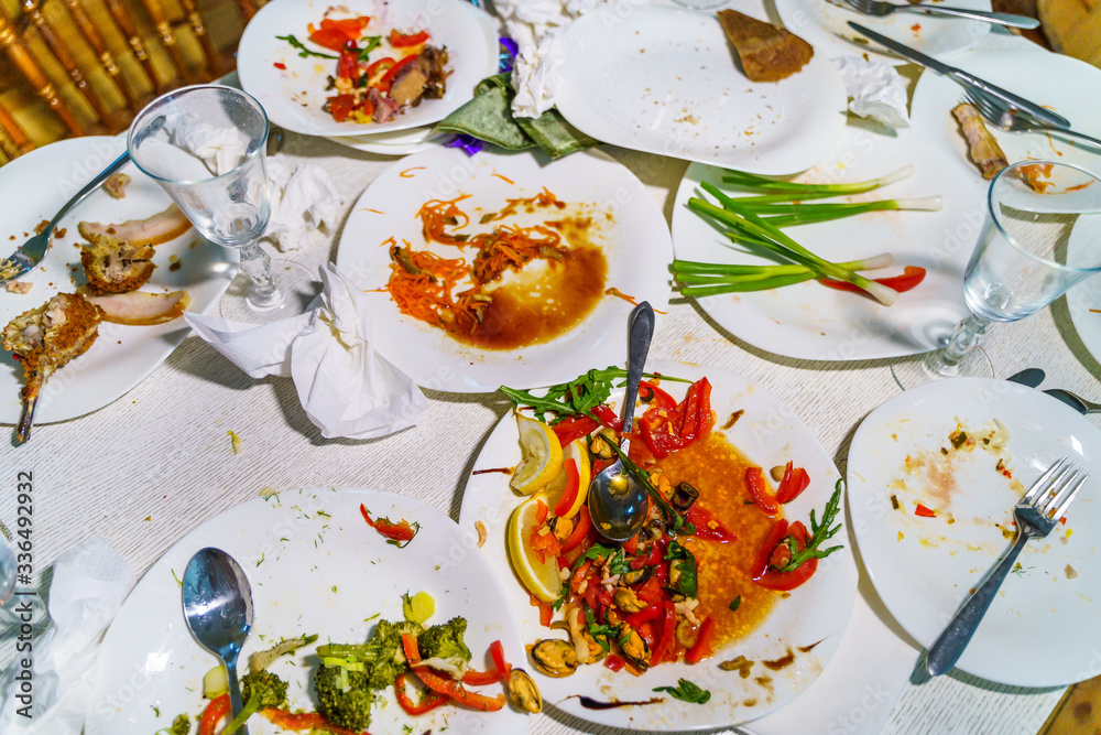 Dirty dishes and glasses on the table after eating. Empty plates with remnants of food after diner.