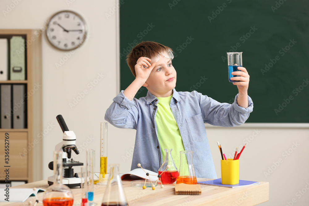 Cute little boy at chemistry lesson in classroom