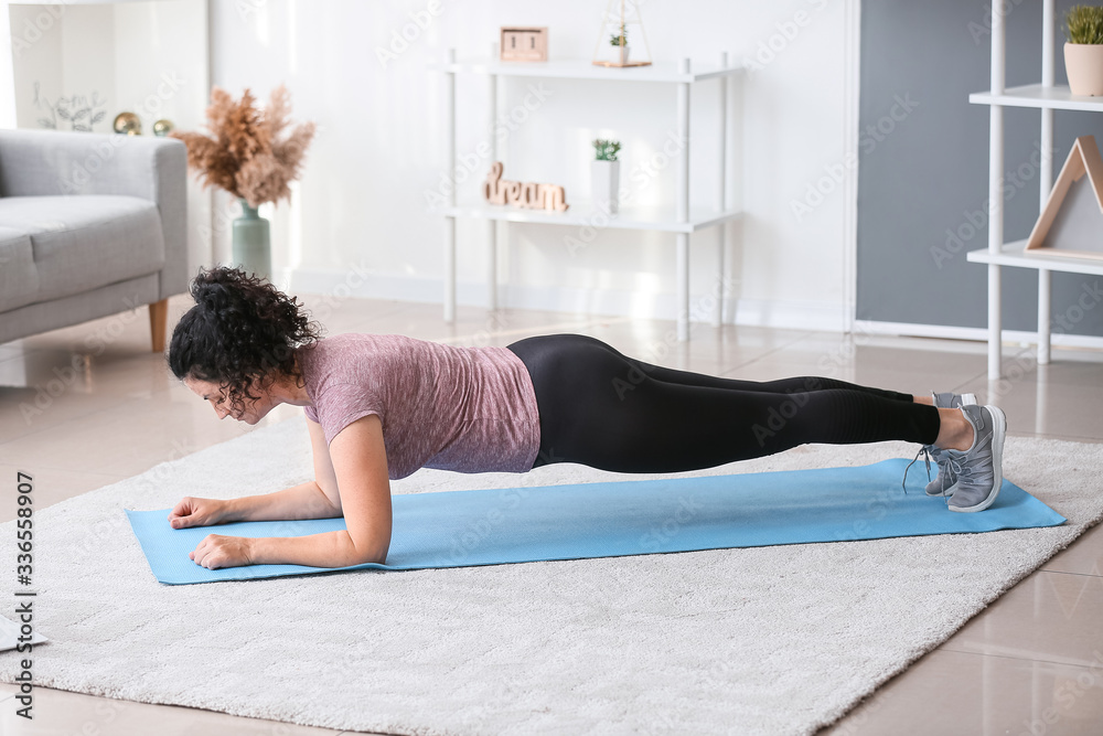 Sporty young woman training at home