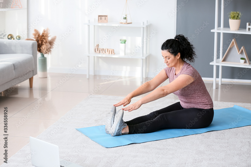 Sporty young woman training at home