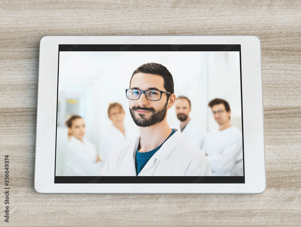 Healthcare, profession, people and medicine concept - smiling male doctor on tablet