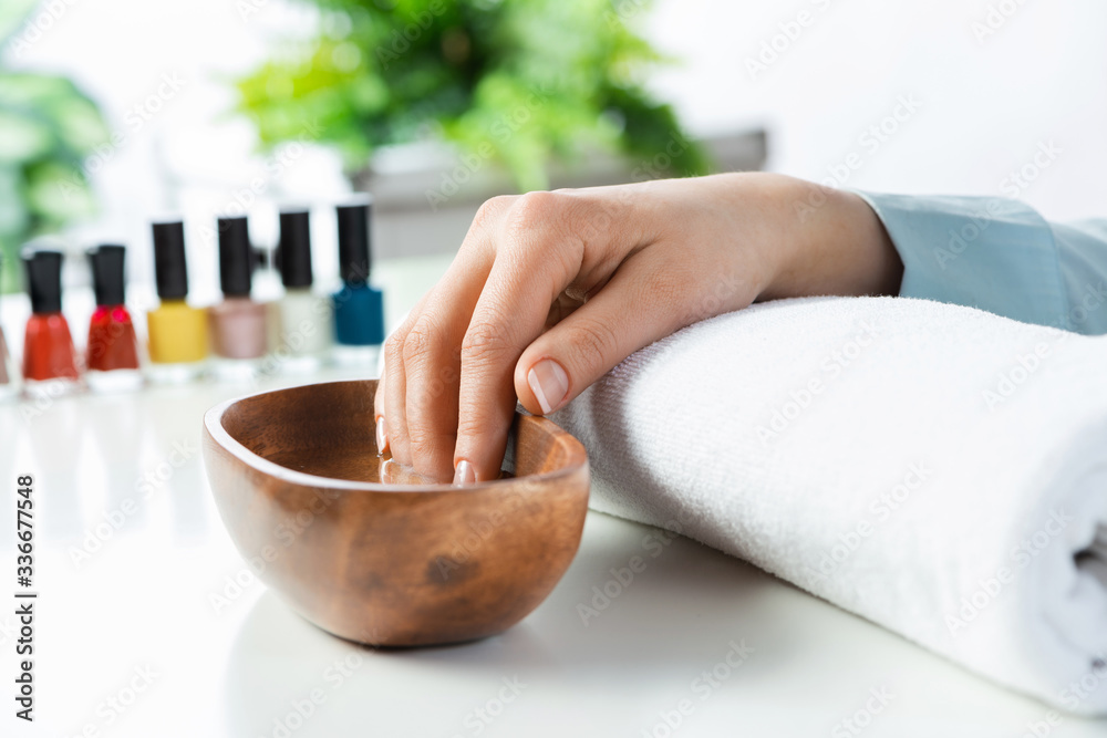 Closeup female hands in wooden bowl with water